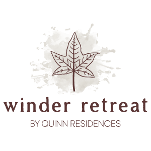 A logo for Winder Retreat by Quinn Residences featuring a leaf.